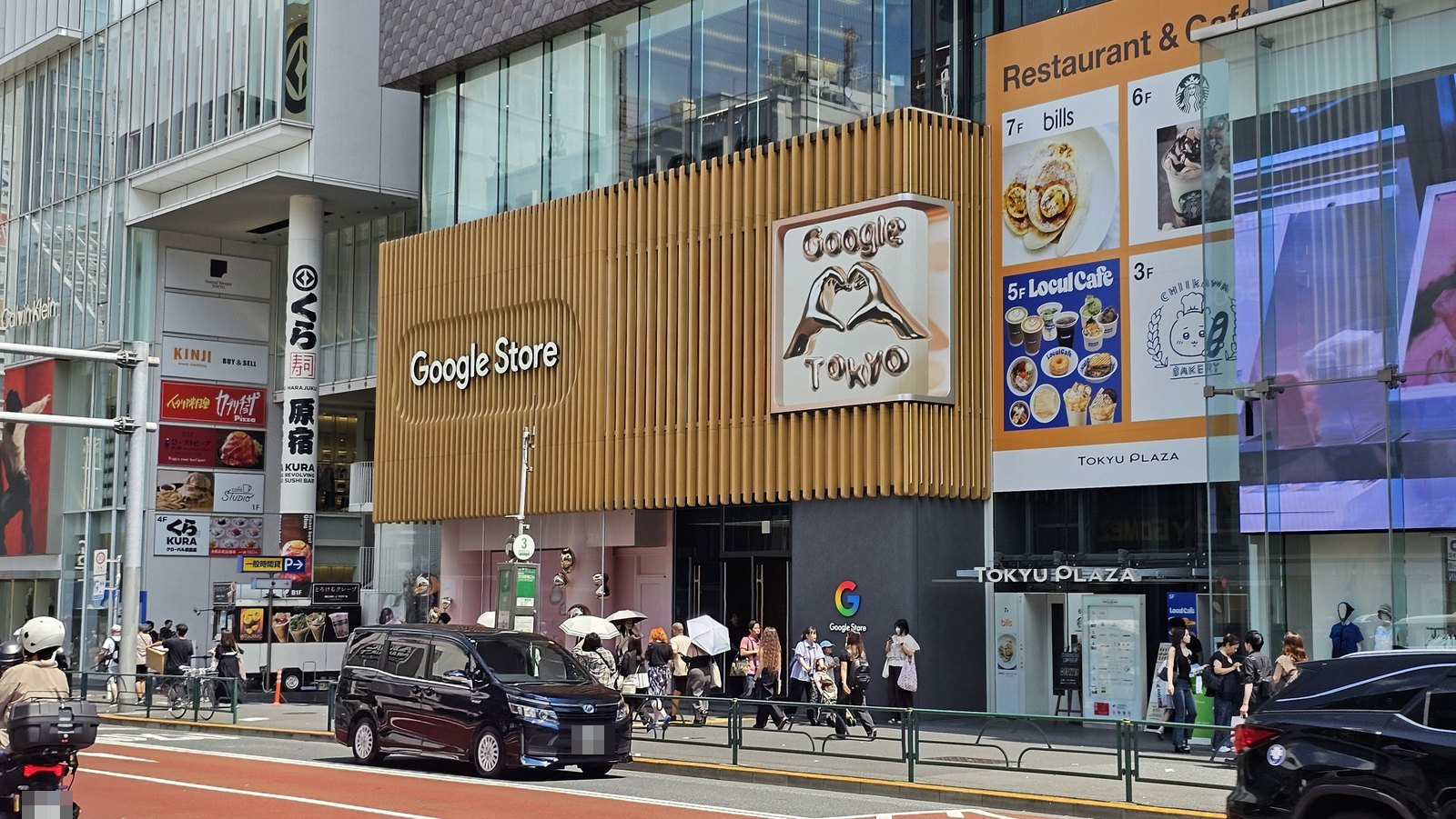 神宮前交差点から見た Google Store 表参道の外観。東急プラザ表参道「オモカド」の壁面が木製ルーバーで覆われ、Google Store のロゴと、手でハートを作るクロームのオブジェが掲げられている