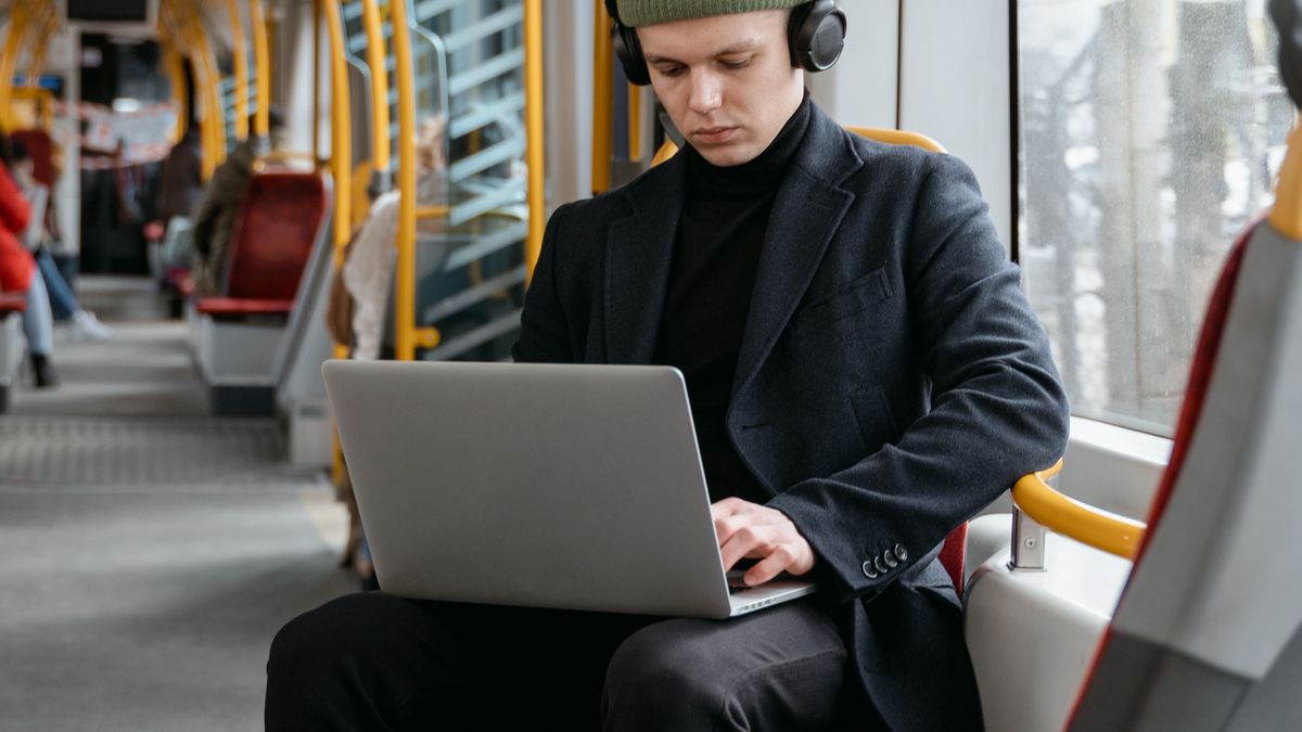 電車内でノートPCを開いて作業する男性